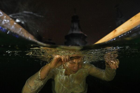 شخص يغطس خلال عيد الغطاس في أراضي كرملين إزمايلوفو (مجمع تراثي) في موسكو - سبوتنيك عربي