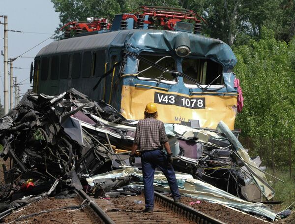  تفحص رجل مجري محرك قطار عقب اصطدامه بحافلة ألمانية عند معبر سكة حديد في مدينة سيوفوك، الواقعة على بعد نحو 110 كيلومترات غرب بودابست بالقرب من بحيرة بالاتون. - سبوتنيك عربي