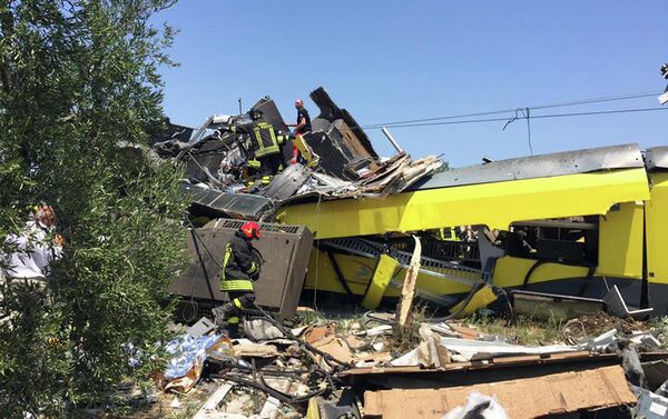 بحث رجال الإطفاء الإيطاليون بين الحطام في موقع حادث قطار وقع عقب تصادم قطارين للركاب وجها لوجه بالقرب من بلدة أندريا في منطقة بوليا جنوبي إيطاليا، ما أسفر عن مقتل عدة أشخاص، في يوليو/تموز 2016.  - سبوتنيك عربي