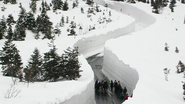 ممر عبر أكوام الثلج العالية، التي تحاوطه من الجانبين، في مدينة أوموري اليابانية. - سبوتنيك عربي