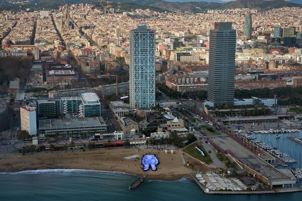 يحمل الناس صورة عملاقة لهند رجب، وهي طفلة فلسطينية تبلغ من العمر خمس سنوات قُتلت خلال الحرب في غزة، على شاطئ في برشلونة، إسبانيا، الخميس، 29 يناير/كانون الثاني 2026. - سبوتنيك عربي