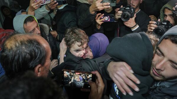 Женщина обнимает одного из своих внуков после того, как они вернулись в Газу после долгожданного открытия КПП Рафах, в больнице Насер в Хан-Юнисе, на юге сектора Газа - سبوتنيك عربي