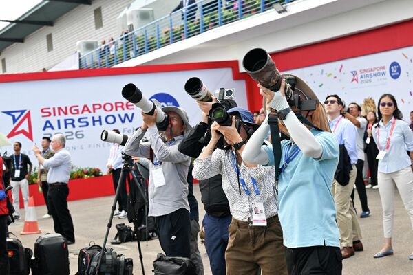 مصورون يلتقطون صورا للعرض الجوي في معرض سنغافورة الجوي بمركز شانغي للمعارض، في سنغافورة. - سبوتنيك عربي