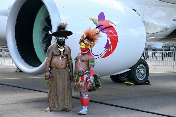 راقصون من بابوا غينيا الجديدة يقفون بجوار طائرة تابعة لشركة طيران نيوجيني، قبل عرض في معرض سنغافورة الجوي بمركز شانغي للمعارض، في سنغافورة في 3 فبراير. - سبوتنيك عربي