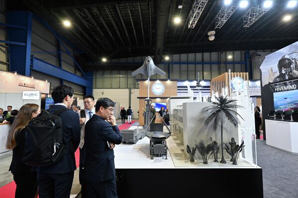 يقف الحضور أمام جناح شركة "شيلد" للذكاء الاصطناعي في معرض سنغافورة الجوي بمركز "شانغي" للمعارض في سنغافورة في 3 فبراير. - سبوتنيك عربي