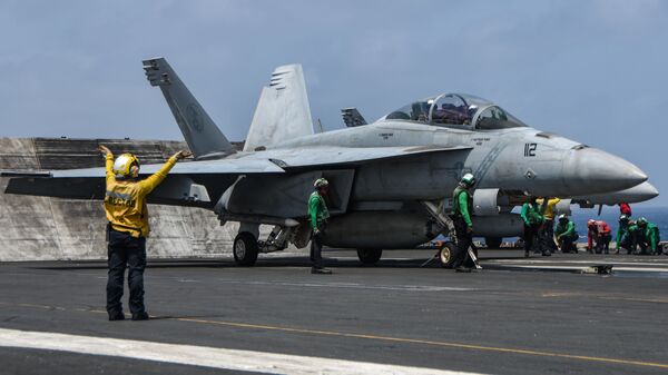 Sailors prepare an F/A-18F Super Hornet fighter jet, attached to the “Diamondbacks” of Strike Fighter Squadron (VFA) 102, to launch from the flight deck of aircraft carrier USS Ronald Reagan (CVN 76) during flight operations in the Arabian Sea, July 8. - سبوتنيك عربي