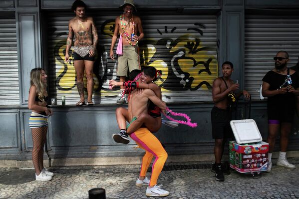 يتعانق المحتفلون خلال حفلة الشارع الاستعدادية للكرنفال "نادا ديمايس" أو "لا شيء مهم" في ريو دي جانيرو. - سبوتنيك عربي