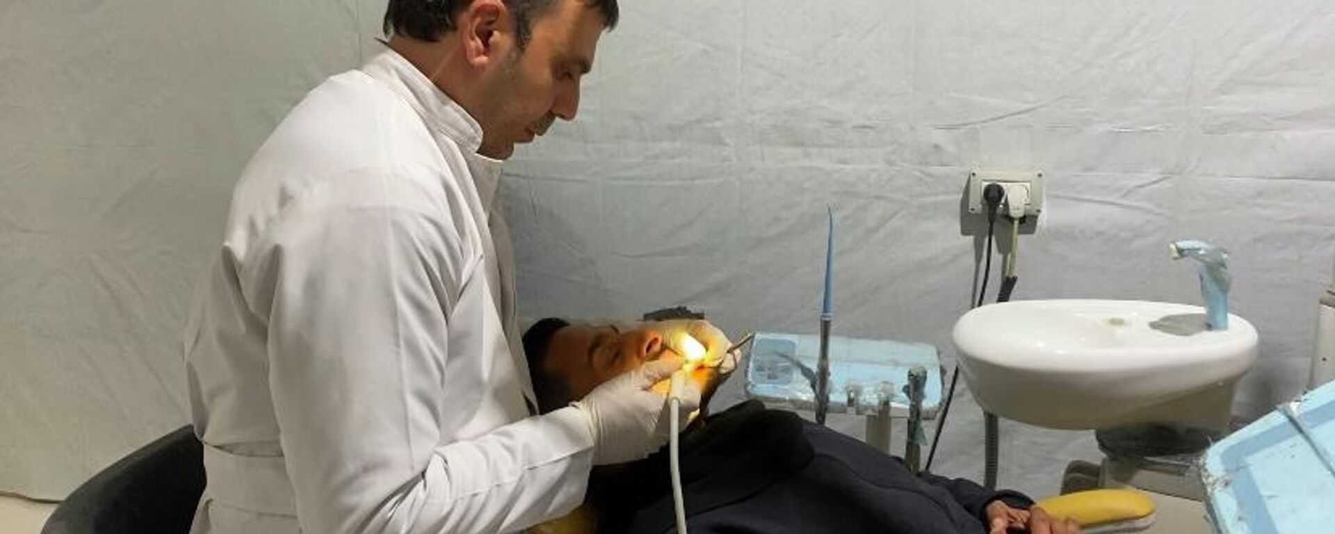 طبيب أسنان يعالج المرضى بين أنقاض منزله المدمر في غزة   - سبوتنيك عربي, 1920, 10.02.2026