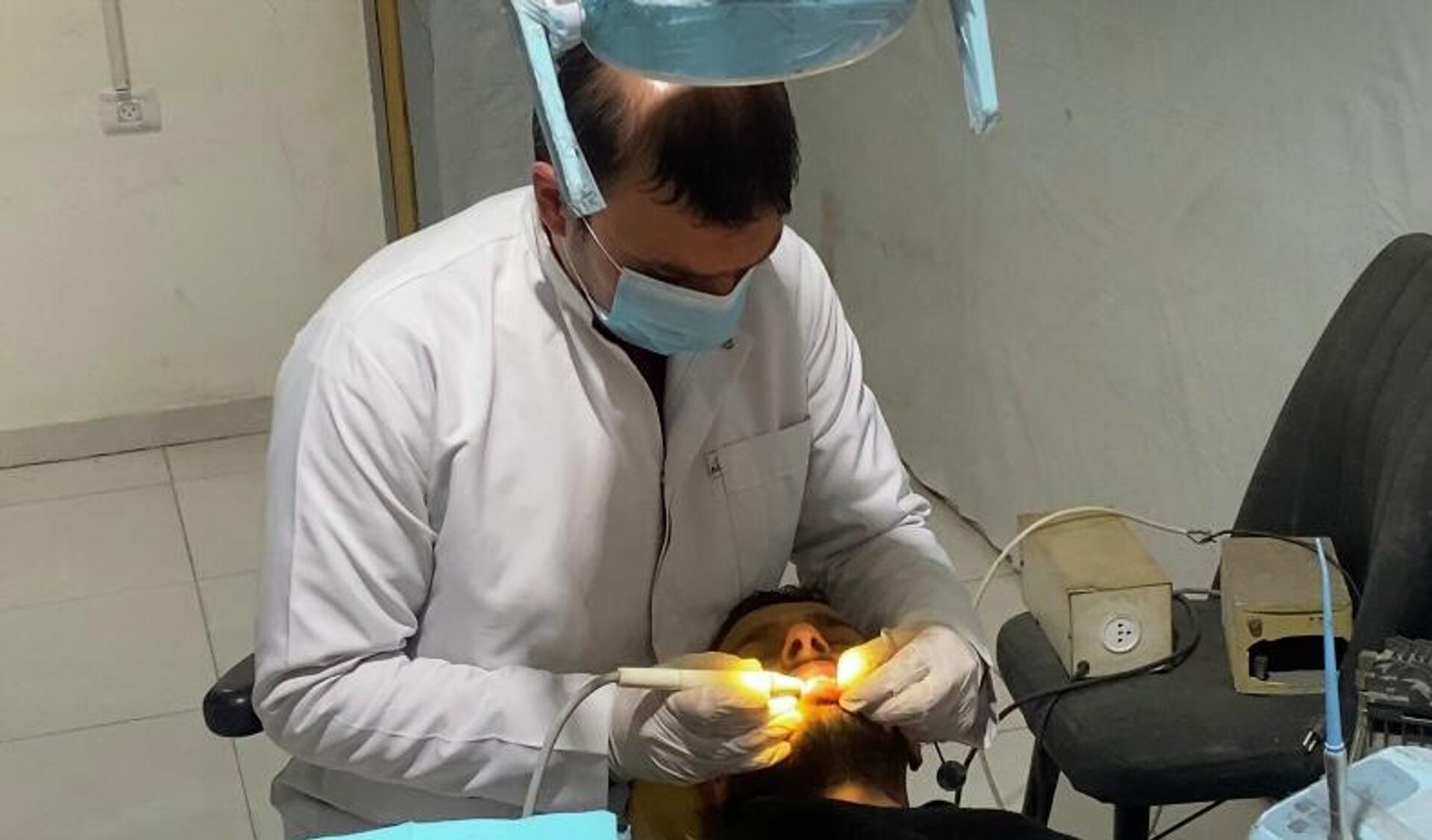 طبيب أسنان يعالج المرضى بين أنقاض منزله المدمر في غزة   - سبوتنيك عربي, 1920, 10.02.2026