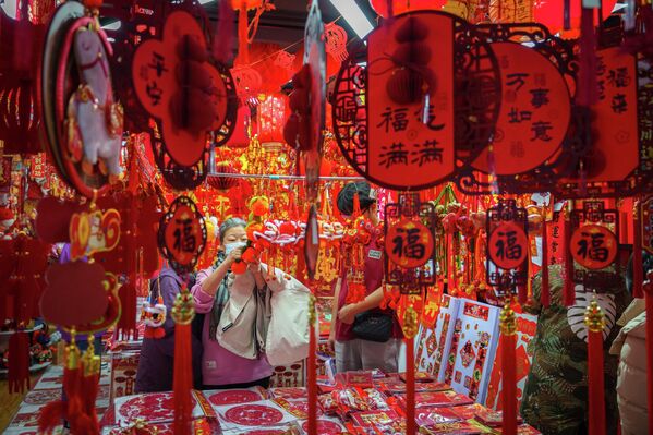 يستعرض المتسوقون زينة رأس السنة القمرية في سوق بمدينة بكين الصينية، يوم الأربعاء 4 فبراير 2026. - سبوتنيك عربي