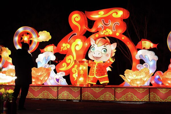 يقف الزوار بجانب صفوف من الفوانيس المضيئة خلال احتفالات رأس السنة القمرية في بكين، الصين.  - سبوتنيك عربي