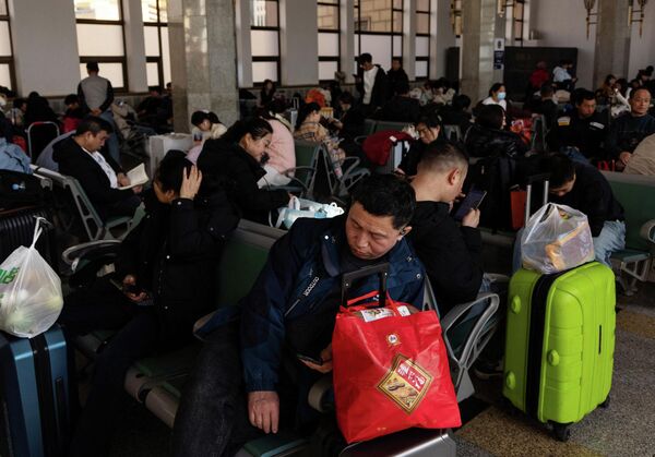 الناس في غرفة الانتظار في محطة السكك الحديدية في بكين خلال عيد الربيع - سبوتنيك عربي