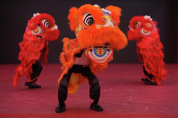 تؤدي روبوتات شبيهة بالبشر ترتدي أزياء رقصة الأسد عروضا على خشبة المسرح خلال عرض إعلامي لمعرض معبد روبوتي قبل حلول رأس السنة القمرية في بكين. - سبوتنيك عربي