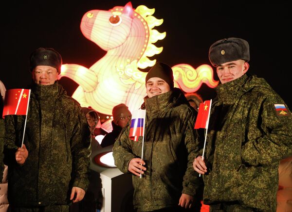 صورة للجنود الروس أثناء تواجدهم في احتفالات رأس السنة الصينية ويحملون في أيديهم أعلام صغيرة لكل من دولتي الصين وروسيا. - سبوتنيك عربي