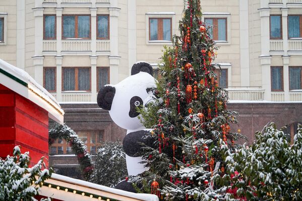صورة تظهر أشجار تم تزيينها احتفاات بالعام الصيني الجديد، ويظهر أيضا شخص يرتدي زي الباندا. - سبوتنيك عربي