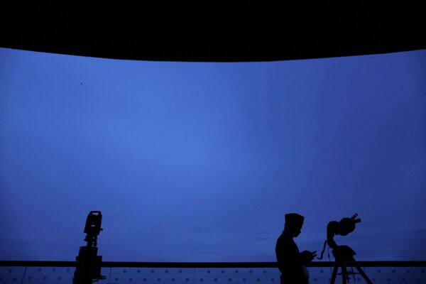 صورة ظلية لموظف في الهيئة الإسلامية الماليزية وأجهزة قياس الزوايا المستخدمة في رؤية الهلال - سبوتنيك عربي