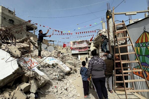 فنان يحول أنقاض المنازل المدمرة في خان يونس إلى لوحات رمضانية احتفالا بالشهر الفضيل - سبوتنيك عربي