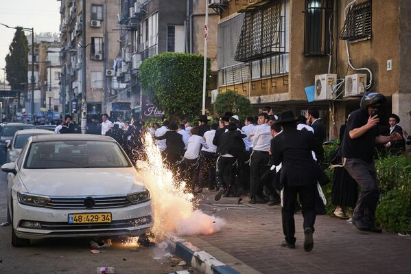 لقطة توثق لحظة انفجار قنبلة صوتية خلال اشتباكات بين الشرطة ورجال يهود متشددين، بعد إنقاذ شرطيتين إسرائيليتين من أعمال شغب اندلعت أثناء زيارة تفقدية في بني براك، إسرائيل - سبوتنيك عربي