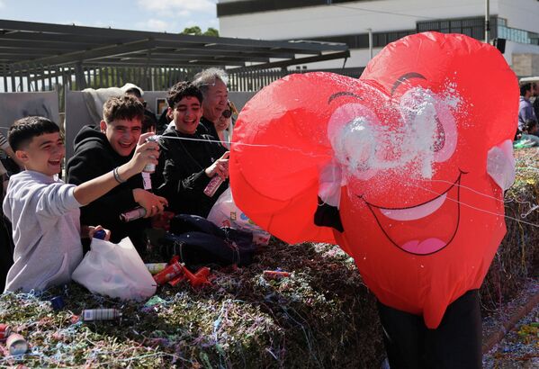 طفل يرش رغوة على أحد المحتفلين المشاركين في موكب كرنفال في نيقوسيا، قبرص - سبوتنيك عربي