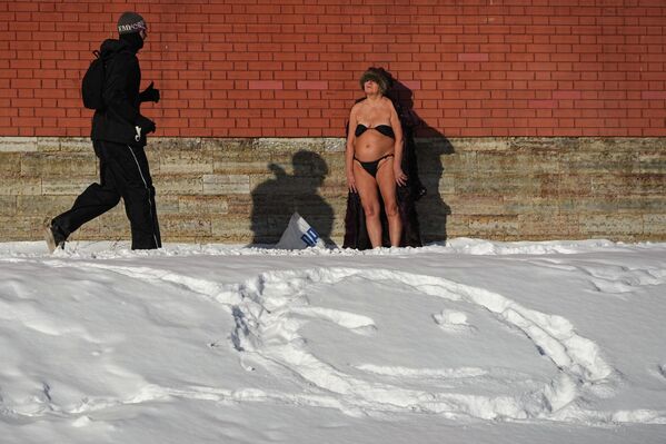 امرأة تستمتع بحمام شمس على ضفاف نهر "نيفا" بدرجة حرارة -15 مئوية، في مدينة سان بطرسبورغ الروسية - سبوتنيك عربي