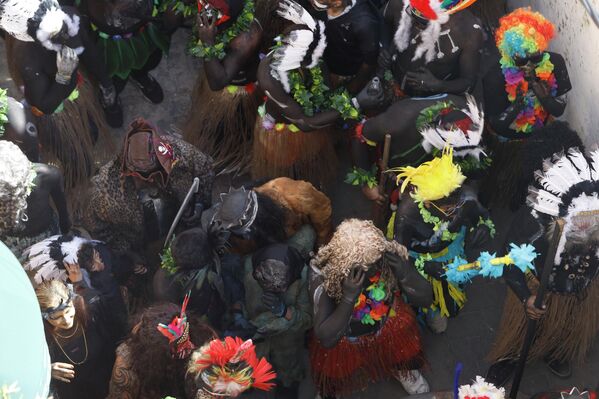 جو من الإثارة والمتعة خلال مسير المشاركين في كرنفال "الزامبو" في شوارع مدينة الميناء، حيث تظهر الرؤوس المزينة بالريش الملون، ودمية على شكل هيكل عظمي. - سبوتنيك عربي