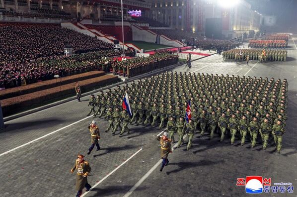 استعراض عسكري مهيب لجنود يسيرون في تشكيل عسكري حاملين أعلام روسيا وكوريا الديمقراطية الشعبية. - سبوتنيك عربي