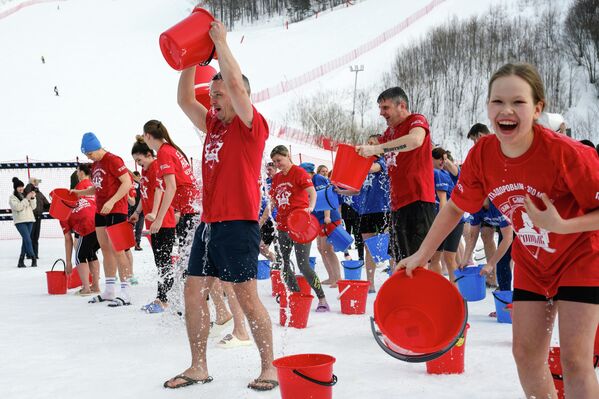 المشاركون في فعالية "الصحة هي الموضة" الرياضية والوطنية، التي تتضمن رش الماء البارد في منتجع غورني فوزدوخ للتزلج في "يوجنو ساخالينسك". - سبوتنيك عربي