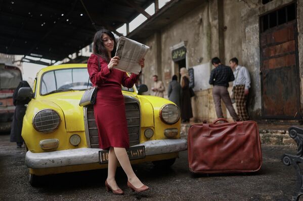 ريتا نصرا، وهي ممثلة كومبارس، تتخذ وضعية لالتقاط صورة أثناء تصوير إحدى حلقات المسلسل التلفزيوني "الأعداء السوريون"، في مدينة حلب، سوريا، والمقتبس من رواية تحمل الاسم نفسه والتي تم حظرها في عهد بشار الأسد. - سبوتنيك عربي