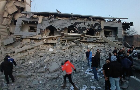 عمال الإنقاذ يتجمعون أمام مركز مبنى مدمر تعرض لغارة إسرائيلية، في مدينة صيدا. - سبوتنيك عربي