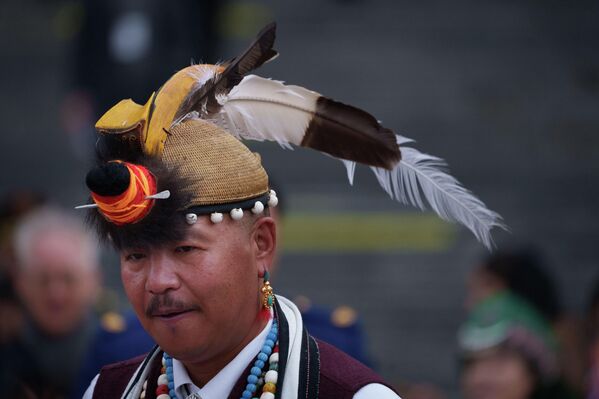 أحد المغادرين من الجلسة الافتتاحية للمجلس الوطني لنواب الشعب في بكين، وهو يرتدي على رأسه قبعة لها ريشة باللون الأبيض والأسود. - سبوتنيك عربي