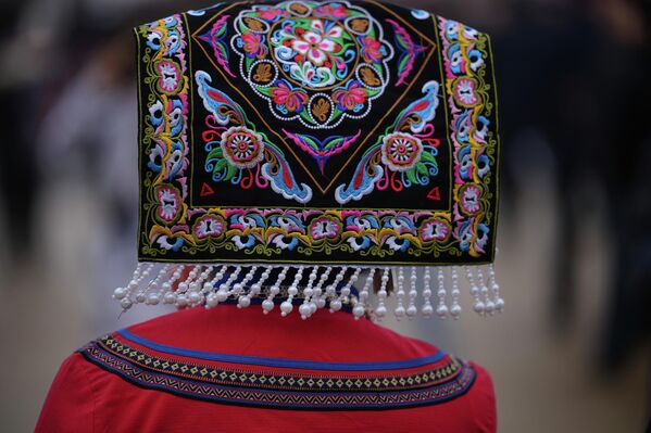 إحدى المندوبات تم التقاط صورة لها وهي تغادر القاعة للجلسة الافتتاحية، للمؤتمر الاستشاري السياسي للشعب الصيني، وتظهر مرتدية قبعة ذات ألوان زاهية. - سبوتنيك عربي