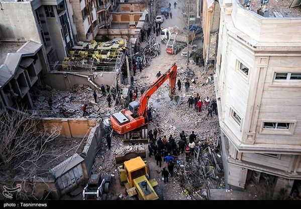 صورة جوية تظهر حجم الدمار، الذي تسببت به غارة جوية أمريكية - إسرائيلية، استهدفت مباني سكنية في همدان، وقيام فرق الإنقاذ بإزالة الأنقاض بحثًا عن ناجين - سبوتنيك عربي