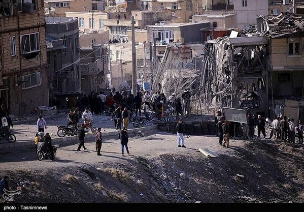 مجموعة من الأشخاص يعاينون الأضرار الكبيرة التي أصابت المناطق السكنية في مدينة سنندج غربي إيران، نتيجة الغارات - سبوتنيك عربي