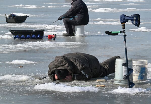 أحدالأشخاص يصطاد سمك الرنجة على الجليد في خليج آمور في بريمورسكي كراي. - سبوتنيك عربي