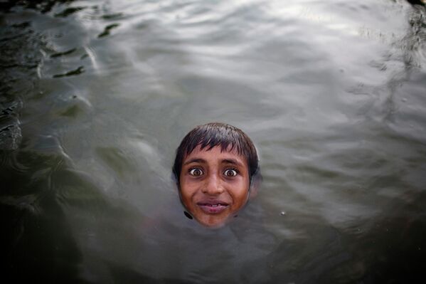 تُظهر هذه الصورة، الملتقطة في 6 أغسطس/آب 2016، راكيب أحمد، وهو طفل عامل مهاجر من بنغلاديش، يستحم خلال استراحة بالقرب من مصنع لإعادة تدوير الألمنيوم خارج دكا. ويعيش العمال المهاجرون بالقرب من نهر بورينجانجا الملوث في خيام مؤقتة، ويعملون 12 ساعة يوميًا في صهر العلب المعدنية والرماد الصناعي وعبوات البلاستيك لتحويلها إلى ألمنيوم خام، دون أي معدات وقاية أو أقنعة واقية من الأبخرة والغبار السام - سبوتنيك عربي