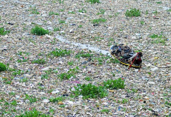 جامع قمامة على متن قارب يجمع مواد قابلة لإعادة التدوير من نهر سيتاروم المليء بالقمامة في باندونغ، غرب جاوة، إندونيسيا، الثلاثاء 8 يونيو 2010  - سبوتنيك عربي