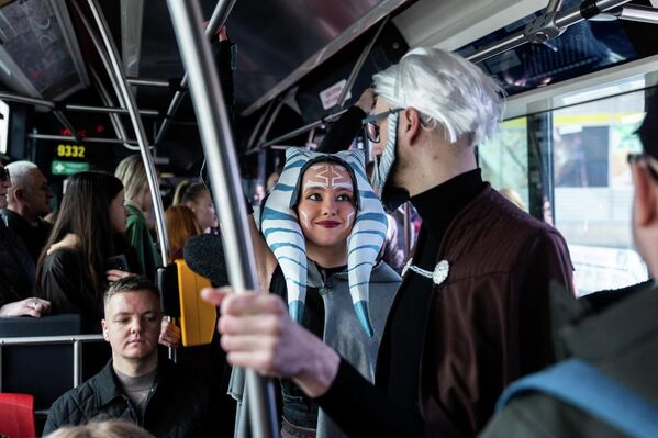 سيدة ترتدي زي أهسوكا تانو من سلسلة أفلام "حرب النجوم"، وبجانبها رجل يرتدي زي الكونت دوكو، يستقلان القطار المتجه إلى معرض "كوميك-كون براغ 2026"، في  التشيك. - سبوتنيك عربي