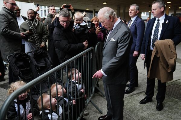 الملك البريطاني تشارلز الثالث  يلتقي بأطفال يقفون خلف ساتر معدني، أثناء مغادرته استوديوهات أفيفا في مانشستر. - سبوتنيك عربي