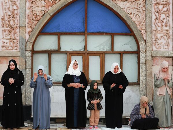 نساء عراقيات خلال أدائهن لصلاة عيد الفطر في مصلى ضريح الشيخ عبد القادر الجيلاني بالعاصمة العراقية بغداد - سبوتنيك عربي