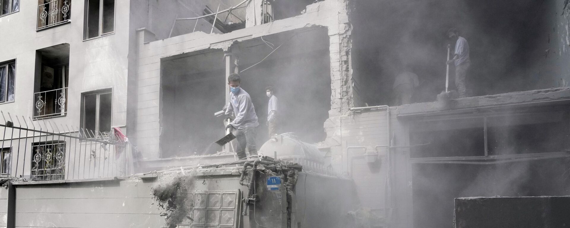 متطوعون يقومون بإزالة الأنقاض من مبنى سكني تضرر بعد استهداف مركز شرطة قريب، وذلك جراء الهجوم الأمريكي الإسرائيلي على العاصمة الإيرانية طهران. - سبوتنيك عربي, 1920, 31.03.2026