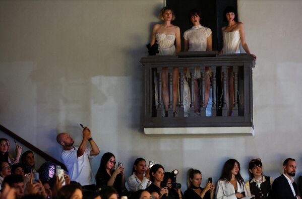 يقوم أحد الحضور بالتقاط صور لعارضات الأزياء خلال عرض المصممة فالنتينا شوخنر ضمن أسبوع الموضة في بوينس آيرس، المعروف باسم باف ويك، في وقت يواجه فيه قطاع النسيج في الأرجنتين واحدة من أعمق أزماته منذ عقود نتيجة تدفق الواردات فائقة الرخص وتراجع الطلب المحلي. - سبوتنيك عربي