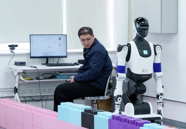 تظهر الصورة عمليات تجميع واختبار الروبوتات الشبيهة بالبشر في مدينة بكين، وذلك ضمن إطلاق أول منصة اختبار تجريبية للروبوتات تابعة لمركز بكين للابتكار في مجال الروبوتات البشرية (X-Humanoid) في العاصمة الصينية في مقاطعة ييتشوانغ الاقتصادية والتكنولوجية للتنمية في بكين. - سبوتنيك عربي