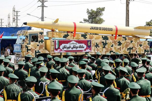  صاروخ باليستي إيراني متوسط ​​المدى يعمل بالوقود الصلب، معروض على آلية عسكرية، وسط حشد من القوات الجوية التابعة للحرس الثوري. - سبوتنيك عربي