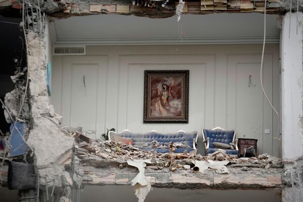 صورة تظهر الأنقاض لأثاث غرفة معيشة مدمرة في مبنى سكني تعرض لهجوم أمريكي إسرائيلي، في العاصمة الإيرانية، طهران. - سبوتنيك عربي