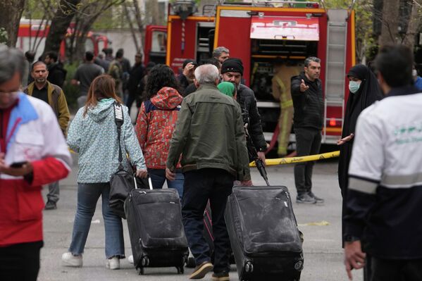 صورة تظهر مغادرة الناس لمنازلهم بعد جمع بعض ممتلكاتهم في مجمع سكني تعرض لغارة أمريكية إسرائيلية بينما كانوا يحتمون في مكان آخر، في طهران، إيران. - سبوتنيك عربي