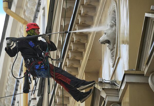 عامل يغسل واجهة أحد المسارح في سان بطرسبورغ، روسيا. - سبوتنيك عربي