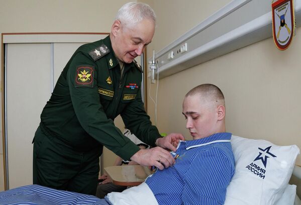 وزير الدفاع الروسي أندريه بيلاؤوسوف، يقدم وسام "النجمة الذهبية" لبطل روسيا الجندي سيرغي ياراشيف، الذي دافع بمفرده عن موقع بالقرب من بلدة غريشينو في جمهورية دونيتسك الشعبية، لمدة 68 يوما - سبوتنيك عربي