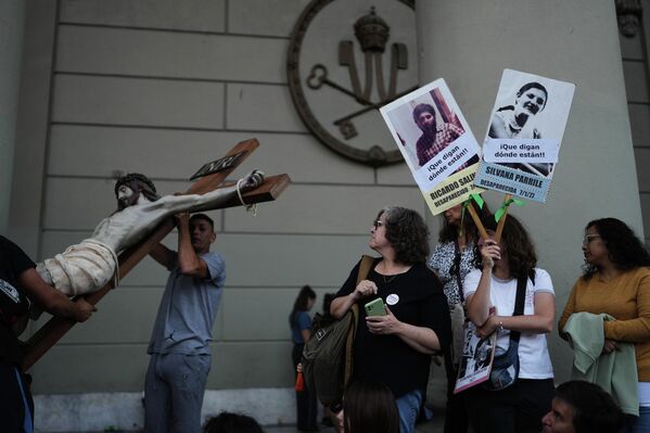 تجمع شعبي في ذكرى الانقلاب الذي أوصل النظام العسكري (1976-1983) إلى السلطة في الأرجنتين، بينما ينقل العمال تمثالًا للسيد المسيح في العاصمة بوينس آيرس - سبوتنيك عربي