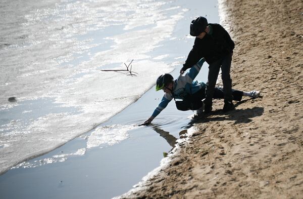 طفلان يلعبان بالمياه داخل حديقة في حي ستروغينو. - سبوتنيك عربي