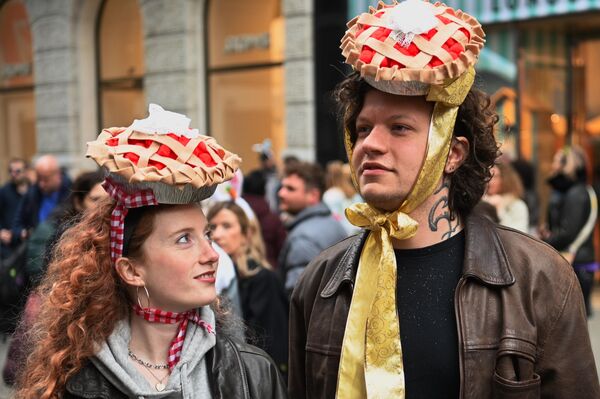 شاب وفتاة يضعان قبعات ملونة خلال مشاركتهما في عيد الفصح السنوي ومهرجان القبعات وسط مدينة نيويورك. - سبوتنيك عربي